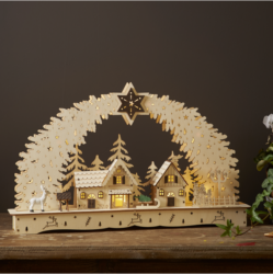 Vánoční dekorace Bamberg 10 LED, Star Trading - Detailně vyřezaný laserem vyřezávaný svícen ze dřeva, ve tvaru oblouku, dva smrky se naklánějí tak, aby se nahoře setkaly v jedné hvězdě. Vše krásně rámuje krajinu malých domků. Svícen je nelakovaný a v přírodní barvě. Umístěte svícen do okna nebo na komodu, abyste získali dokonalý vánoční pocit.
