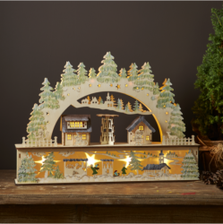 Vánoční dekorace Bamberg 12 LED, Star Trading - Detailně vyřezaný laserem vyřezávaný svícen ze dřeva, základna má krásně vyřezávanou krajinu s malými domky a nad základnou se ohýbá oblouk se smrky, který rámuje malou detailně propracovanou vesnici. Svícen je nelakovaný se zelenými detaily, díky čemuž je krásně přirozený.

 Ozdobte adventně a vánočně interiér, umístěte svícen do okna nebo na komodu, abyste získali dokonalou vánoční atmosféru.